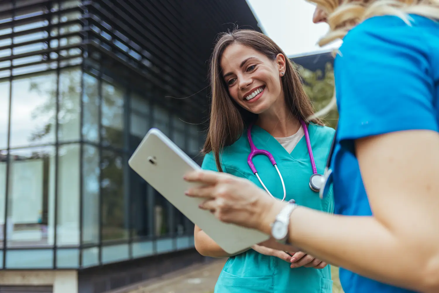 Ein kleines Team medizinischer Mitarbeiter sitzt um einen Konferenztisch herum, um Patientenfälle zu besprechen und gemeinsam daran zu arbeiten.